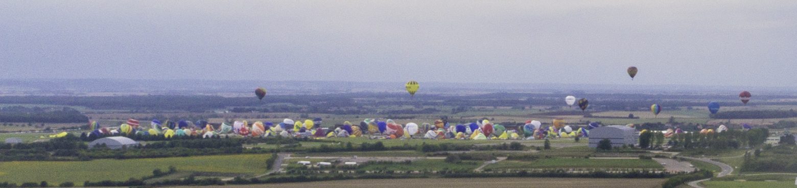 Survol... de loin d'un décollage massif de montgolfières par temps très moyen.